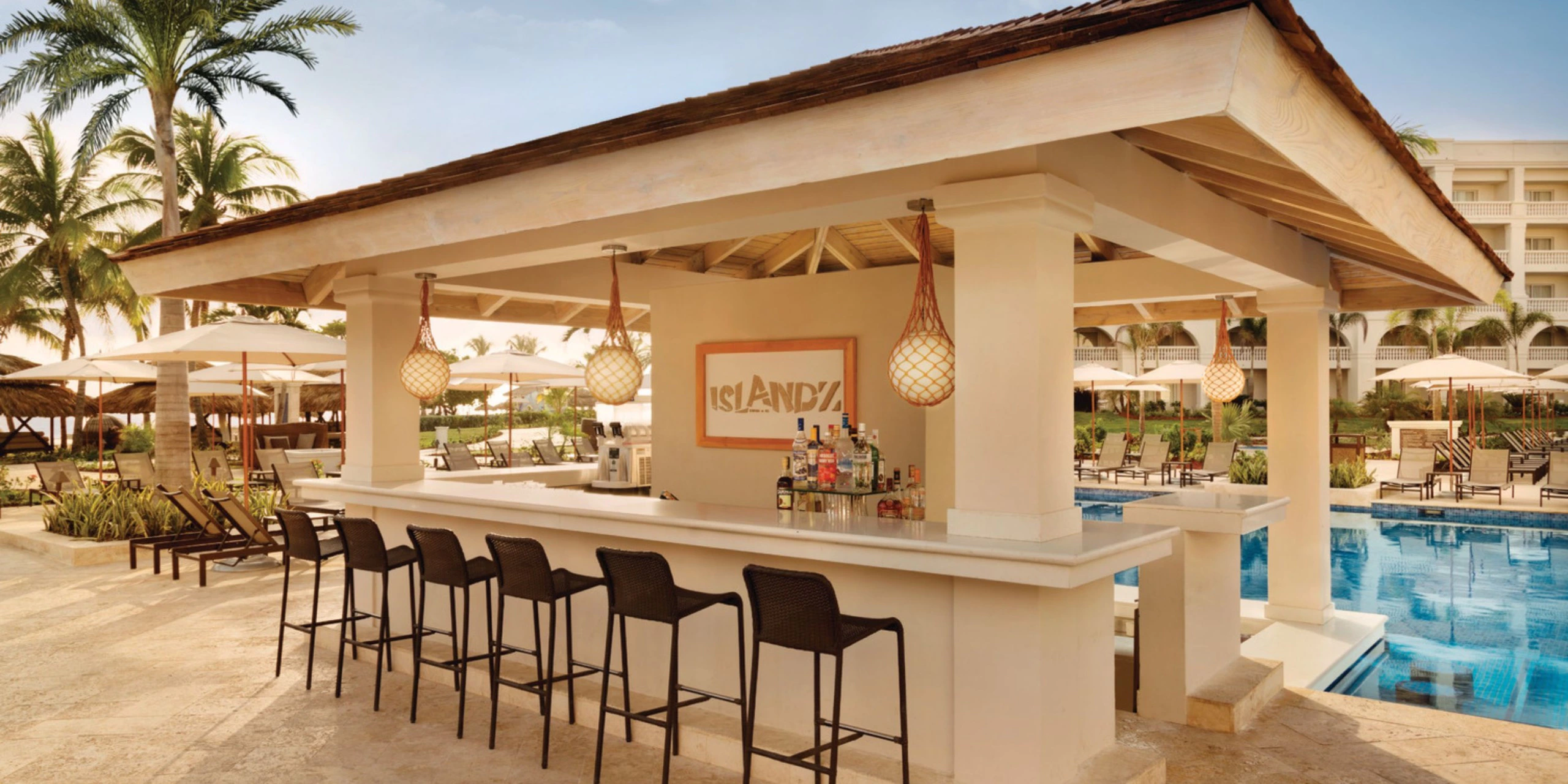 Open-air pool bar with swim-up seating and tropical surroundings at Hyatt Zilara Rose Hall.