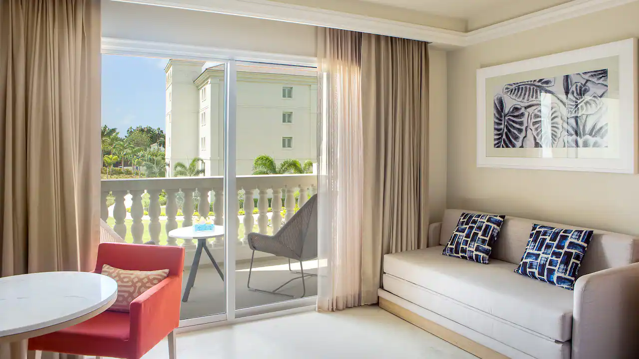 King room sitting area with sofa and furnished balcony at Hyatt Zilara Rose Hall.