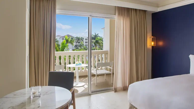 Ocean View King room with furnished balcony overlooking tropical gardens and the Caribbean Sea at Hyatt Zilara Rose Hall.