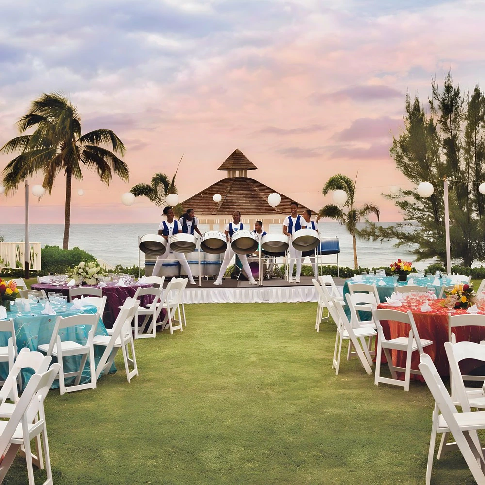 Outdoor wedding reception with live entertainment on an oceanfront lawn at Hyatt Zilara Rose Hall.