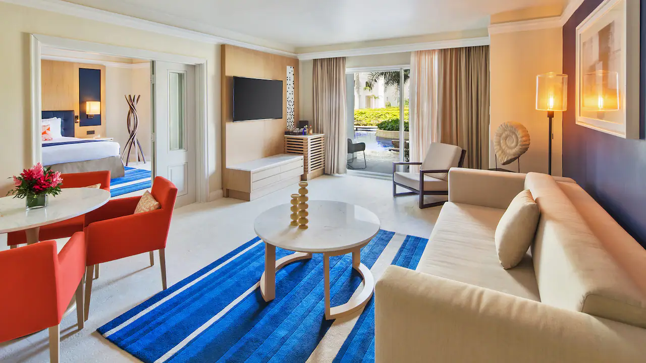 Living room in the One Bedroom Swim-Up Suite with terrace access at Hyatt Zilara Rose Hall.